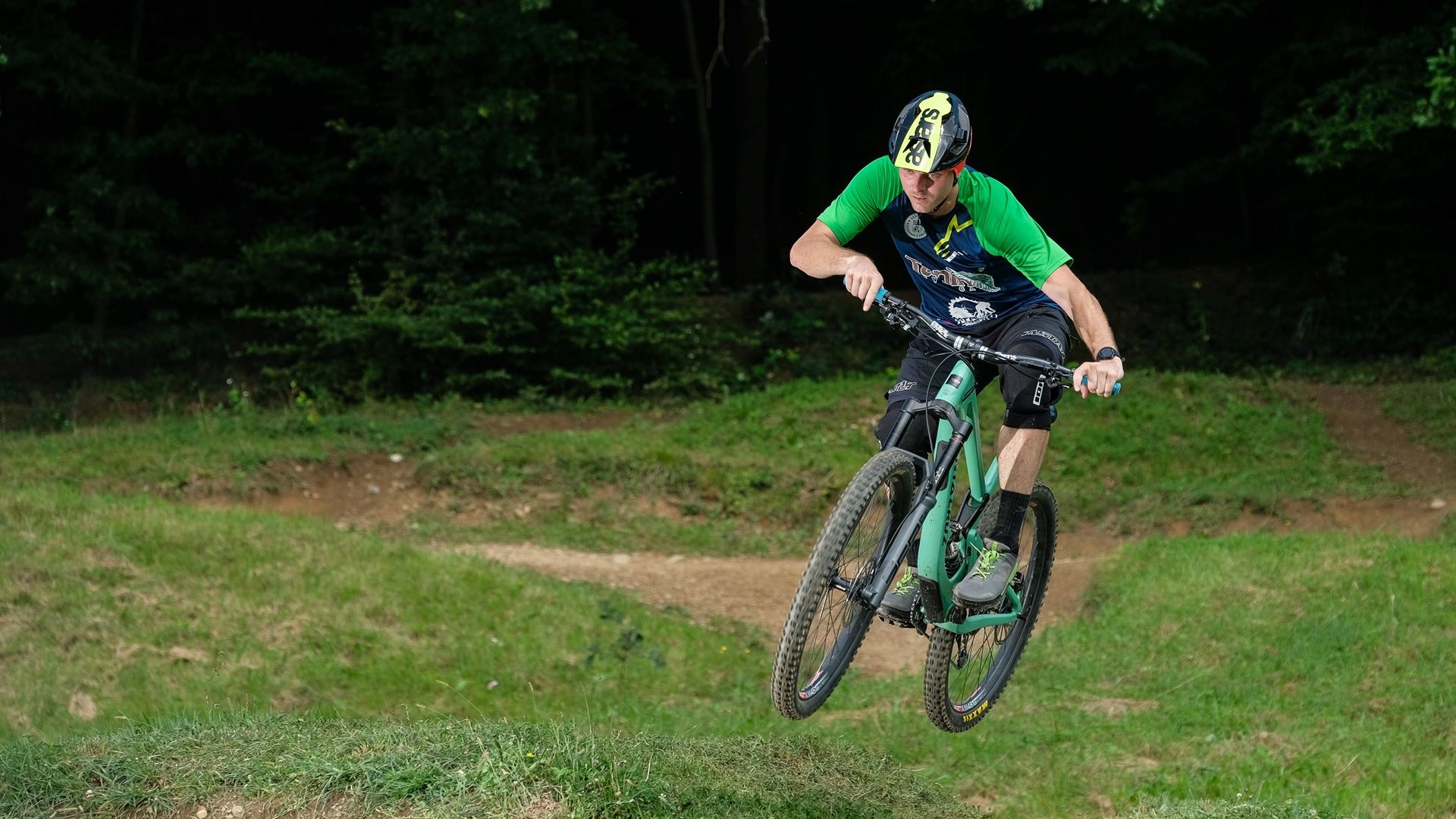 Fotografija kolesarja, ki izvaja trik v zraku.